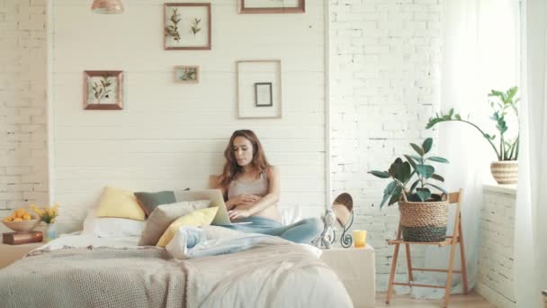 Femme enceinte gaie utilisant un ordinateur portable à la maison. Attendre maman salon chambre . — Video