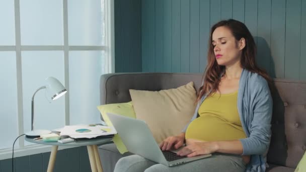 क्लोजअप पेट माँ कार्य दिवस के बाद आराम कर रही है। गर्भवती माँ पेट पकड़े हुए — स्टॉक वीडियो