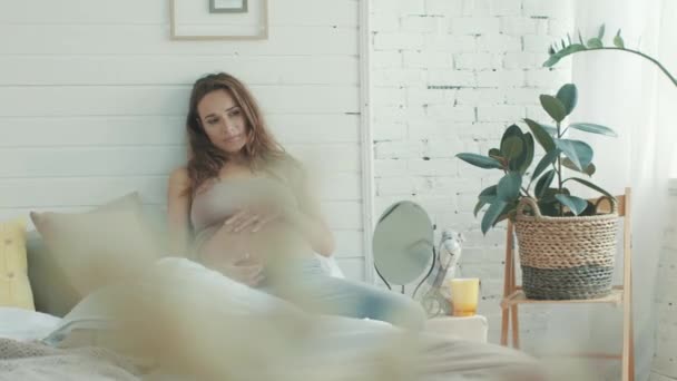 Expectant mother feeling pregnant pain at home.Tense belly mother sitting bed. — Stok video