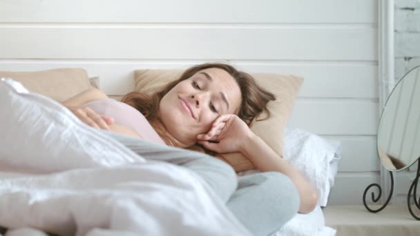 Close-up gelukkig zwanger vrouw glimlachen naar haar buik in de ochtend slaapkamer. — Stockvideo
