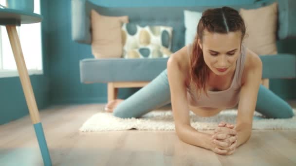 Ожидающая крупным планом мама практикует йогу. Улыбающаяся беременная женщина растягивает ноги — стоковое видео