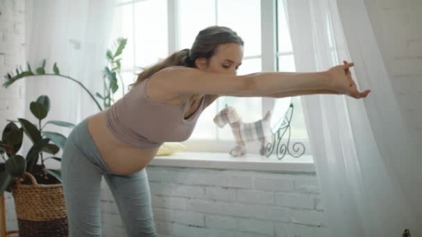 Närbild gravid kvinna gör morgonövningar nära fönstret hemma. — Stockvideo