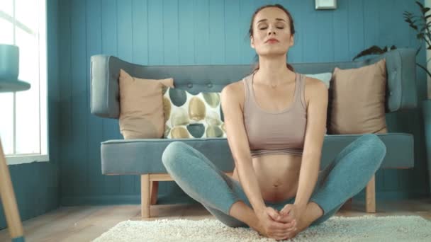 Vacker gravid kvinna som gör yoga på golvet. Förväntad mamma med träning — Stockvideo