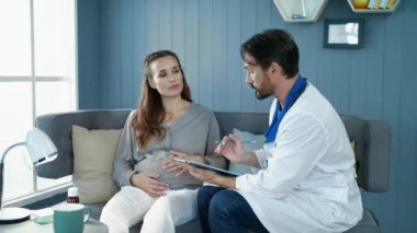 Doğum öncesi kabinede doktor tavsiyelerini dinleyen hamile kadın..