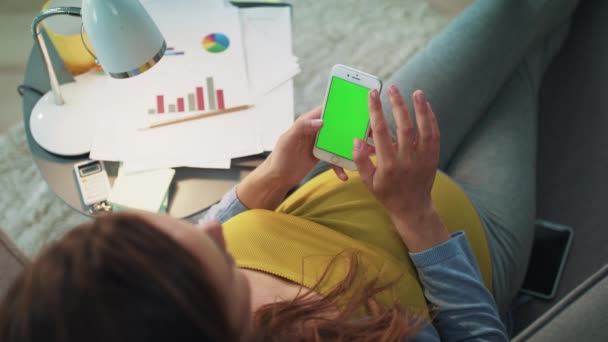 怀孕的女商人下班后用绿色屏幕智能手机放松一下. — 图库视频影像