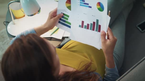 Vue du dessus de la femme d'affaires enceinte vérifiant les graphiques au bureau à domicile . — Video