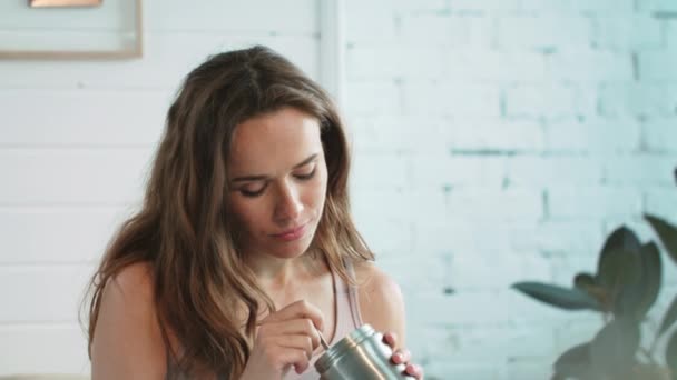 Close-up aantrekkelijke vrouw het eten van ijs met lepel uit metalen pot thuis. — Stockvideo