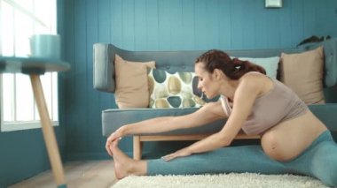 Closeup pregnant woman stretching body in living room in slow motion.
