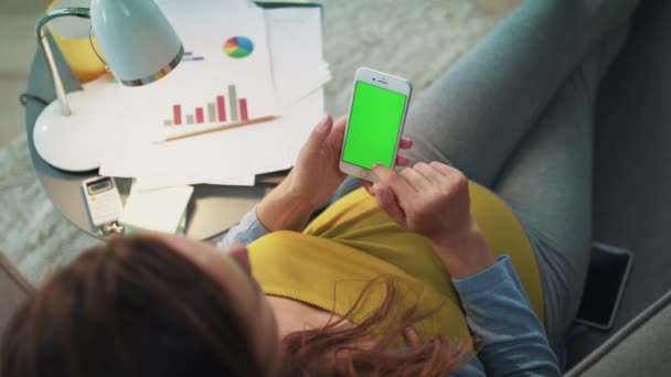 Vista superior de la mujer embarazada escribiendo en el teléfono inteligente con pantalla verde en casa . — Vídeo de stock