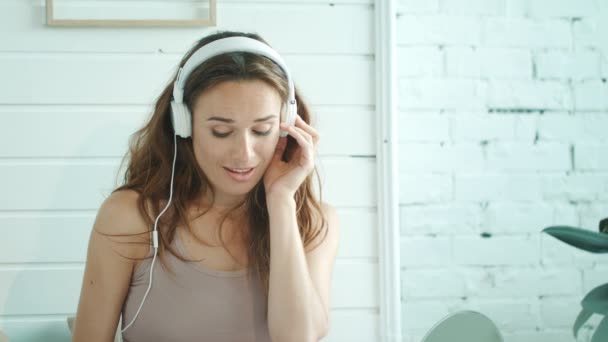Zbliżenie ciężarnej kobiety słuchającej muzyki w domu. Uśmiechnięta oczekująca matka. — Wideo stockowe