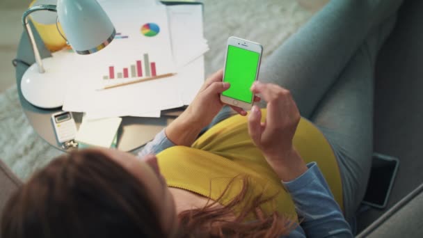 Top weergave van zwangere vrouw met smartphone met groen scherm thuis. — Stockvideo