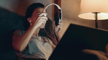 Kadın dizüstü bilgisayardan film izlemeye başlıyor. Esmer kulaklıkla müzik dinliyor..