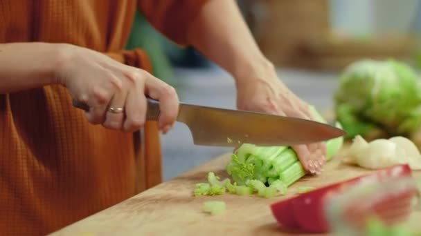 Mani di donna che tagliano sedano sul tagliere. Casalinga cucinare verdure fresche — Video Stock