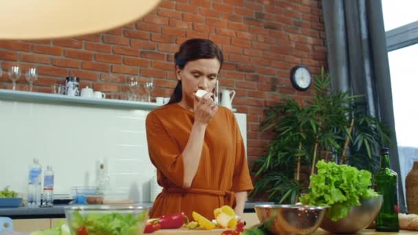 Girl preparing vegetable salad in kitchen. Woman smelling fresh onion bulb. — Stockvideo