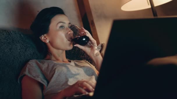 Mulher bebendo vinho tinto com laptop. Menina navegar na internet no computador . — Vídeo de Stock