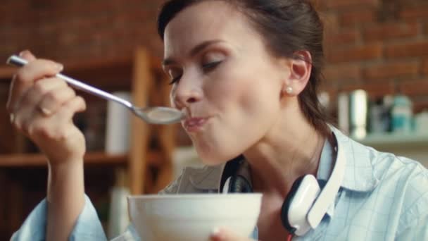 Mutfakta mısır gevreği ve süt yiyen bir kadın. Kahvaltıda mısır gevreği yiyen kız. — Stok video
