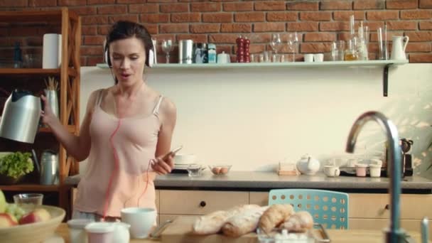 Ragazza che balla godendosi la colazione. Donna che ascolta musica in cuffia. — Video Stock