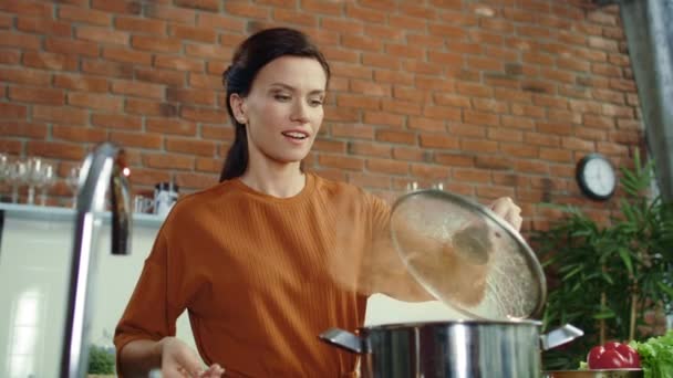 Γυναίκα φτιάχνει σούπα στην κουζίνα. Κορίτσι που προσθέτει αλάτι σε κατσαρόλα που βράζει. — Αρχείο Βίντεο