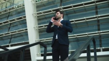 Closeup businessman talking phone outside. Businessman checking time on watch