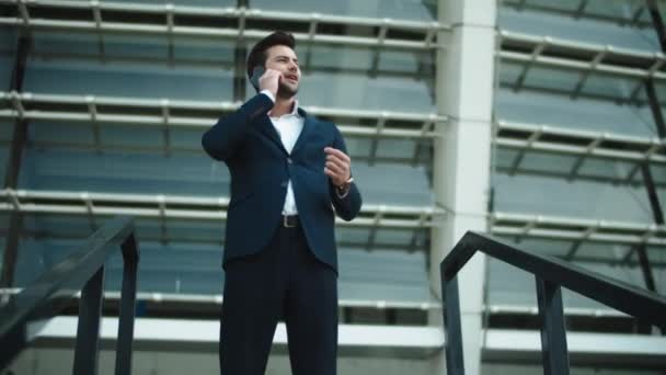 Uomo da primo piano in piedi vicino allo stadio. Uomo d'affari parlando smartphone in strada — Video Stock