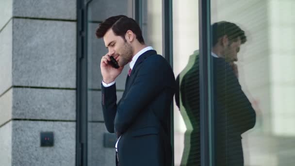 Biznesmen z bliska stoi na ulicy. Mężczyzna uśmiechający się podczas rozmowy telefonicznej na ulicy — Wideo stockowe