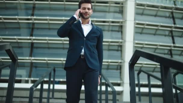 Businessman walking downstairs at street. Man using mobile phone outdoors — 图库视频影像