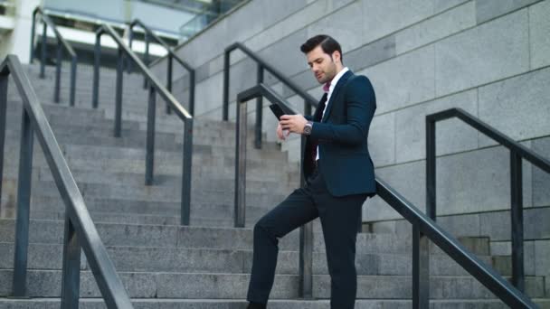 Biznesmen śmiejący się z telefonu na ulicy. Mężczyzna za pomocą smartfona outdoor — Wideo stockowe