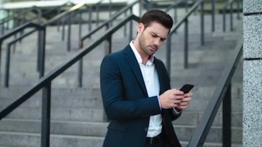 Kapıda, merdivenlerde telefonla daktilo eden adam. Dışarıda cep telefonu kullanan bir adam.
