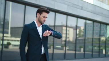 Closeup man standing near business building. Businessman waiting in suit outdoor