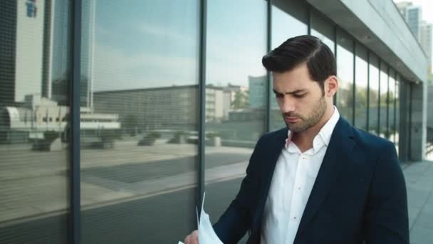 Retrato hombre de negocios mirando a través de documentos. Hombre de negocios tirando papeles — Vídeos de Stock