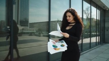 Closeup woman entrepreneur walking at street. Woman reading documents outdoors