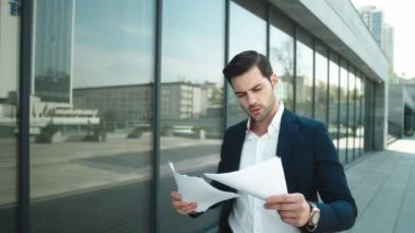 Portrait of businessman walking in slow motion. Business man throwing papers