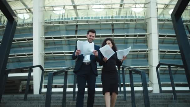 Couple walking stairs in formal clothing. Couple throwing papers in slow motion — Stockvideo