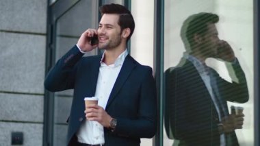 Closeup businessman smiling outdoors. Businessman drinking take away coffee