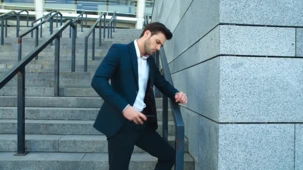 Hombre de negocios con vista lateral parado con teléfono en la calle. Hombre sonriendo con el teléfono — Vídeos de Stock