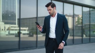 Closeup man taking phone out of pocket. Businessman celebrating victory outdoor