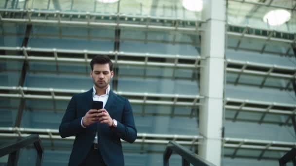 Retrato de hombre de negocios bajando las escaleras. Hombre haciendo una llamada telefónica en traje al aire libre — Vídeo de stock