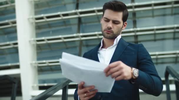Portrait businessman reading documents. Businessman looking away at street — Stok video