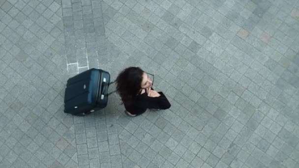 Mujer de vista superior caminando con maleta al aire libre. Mujer posponiendo gafas de sol — Vídeos de Stock