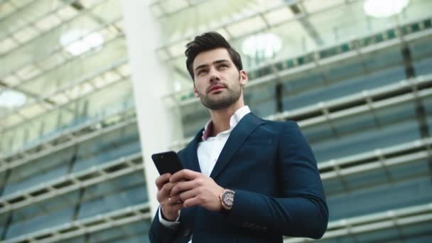 Retrato de hombre de negocios usando el teléfono. Hombre mirando hacia otro lado en traje elegante en la calle — Vídeo de stock