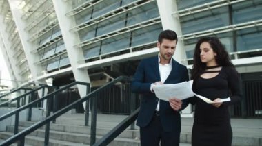 Closeup couple discussing documents near stadium. Couple discussing project