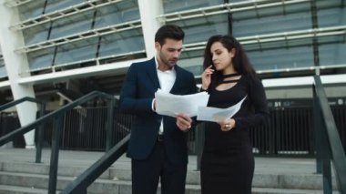 Closeup couple standing with papers. Couple analyzing documents outside