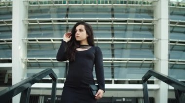 Portrait woman touching hair at street. Woman entrepreneur walking downstairs