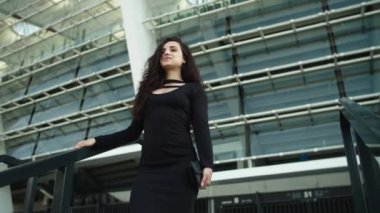 Portrait woman touching hair at street. Woman smiling in black elegant outdoors