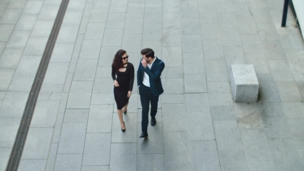 Top view χαρούμενο ζευγάρι περπάτημα στο δρόμο. Επαγγελματικό ζευγάρι χαμογελά σε εξωτερικούς χώρους — Αρχείο Βίντεο