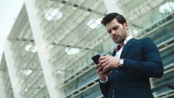 Portret zakenman kijkt weg. Zakenman die gebruik maakt van smartphone buiten — Stockvideo