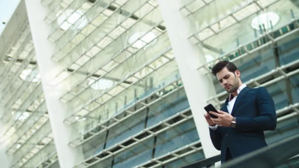 Closeup business man standing with phone. Man using smartphone near stadium — Stockvideo