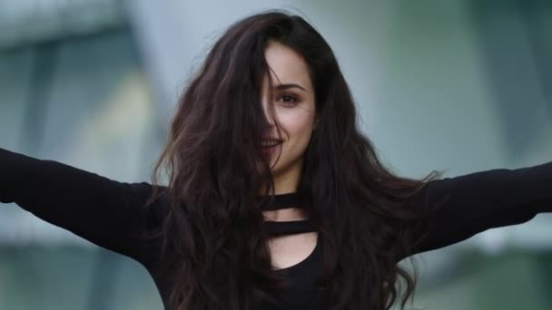 Mujer retrato sacudiendo el pelo en la calle. Mujer mirando a la cámara al aire libre — Vídeo de stock