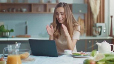 Woman talking with friend online on laptop. Lady gesturing on web camera at home