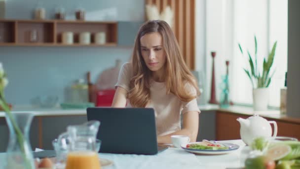 Businesswoman using laptop at home. Woman working on laptop at remote workplace — Stock Video